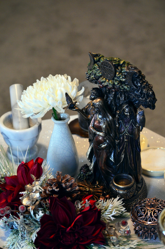 Black Ceramic Figurine on Table with Flowers